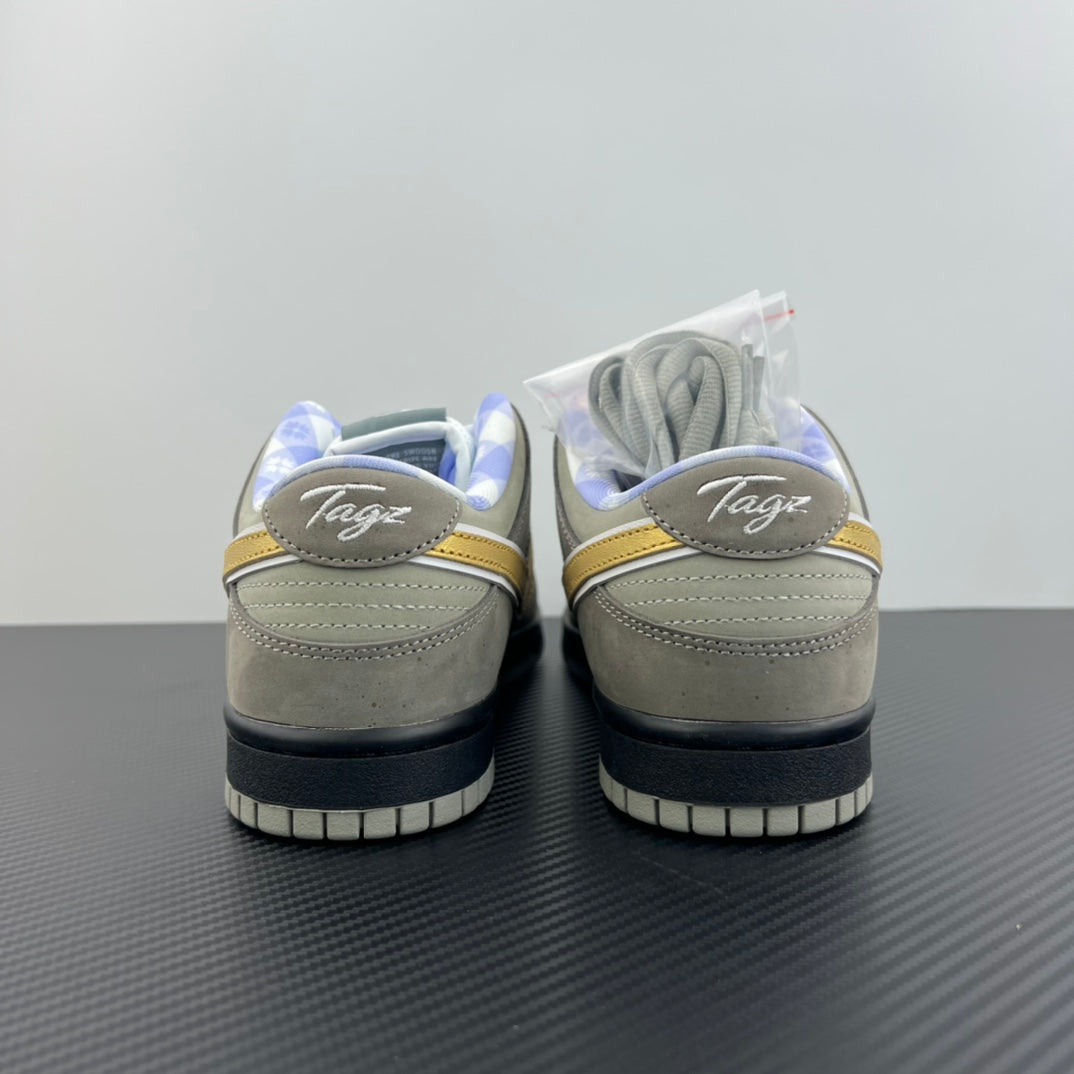 Grey suede sneakers with white laces, yellow swoosh, and black heel panels