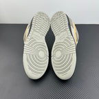 Grey sneaker outsole view with deep traction tread and circular grooves