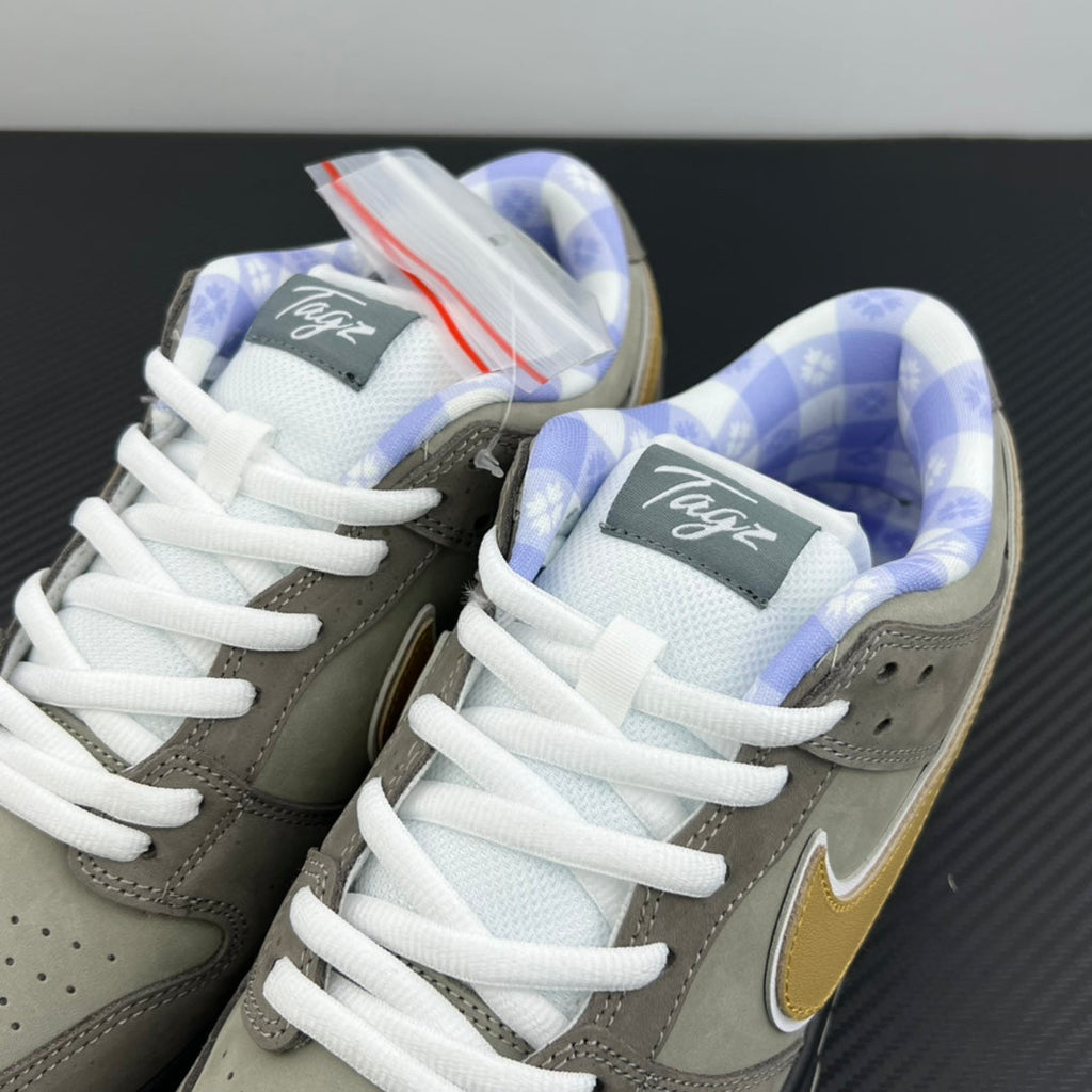 Grey sneaker pair with yellow swoosh, white laces, and blue patterned insoles
