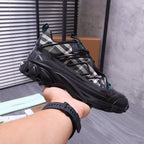 Burberry chunky sneakers, black with plaid panel and teal lace details, on hand view
