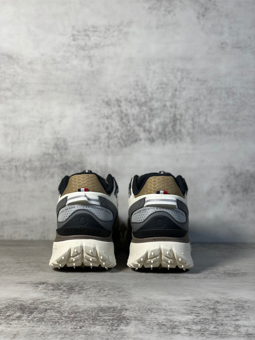 Moncler trail sneaker heel view, white and dark panels with chunky tread