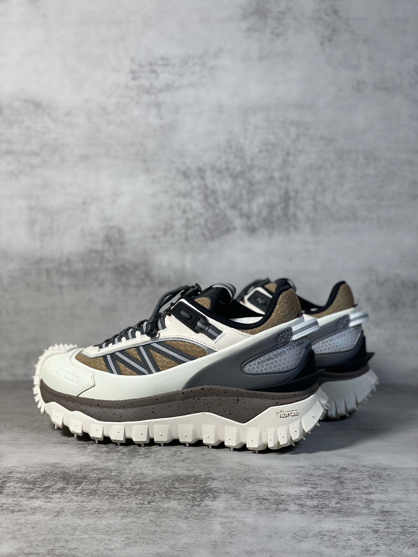 Moncler trail sneaker, low side angle, white base with navy stripe and gray trim