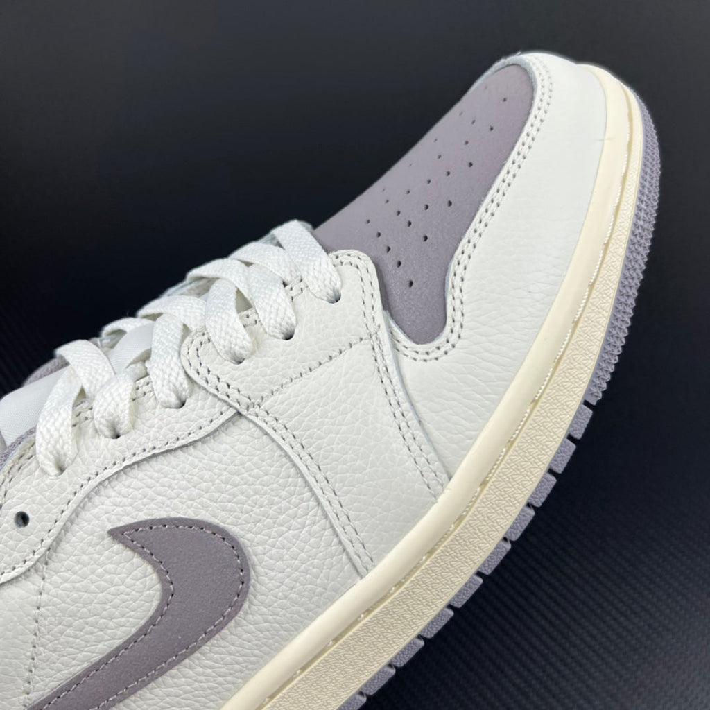 White and light gray low-top sneakers with swoosh logo and lace-up closure.