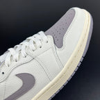 White and light gray low-top sneakers with swoosh logo and lace-up closure.