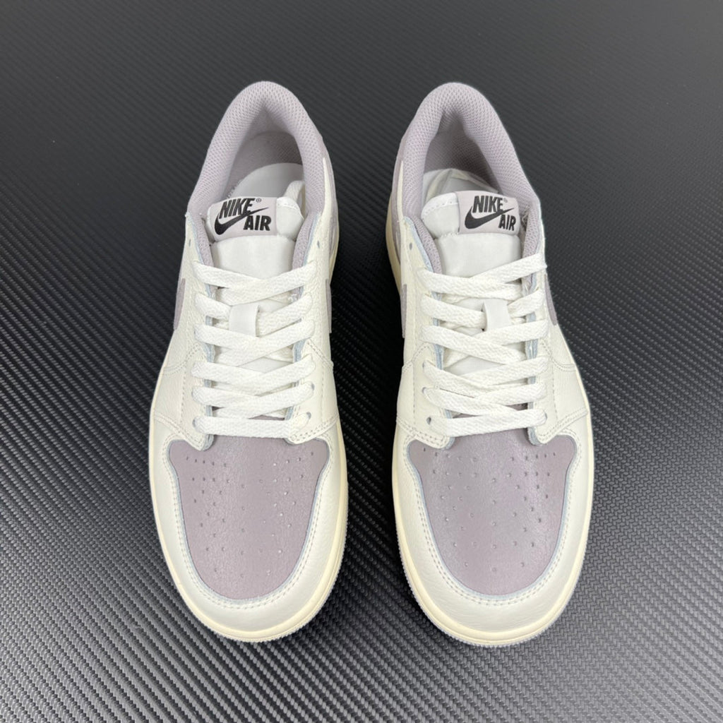 Pair of low-top sneakers in white with lavender-gray suede toe and lace-up front.