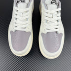 Front view of white low-top sneakers with perforated toe and lavender-gray overlays.