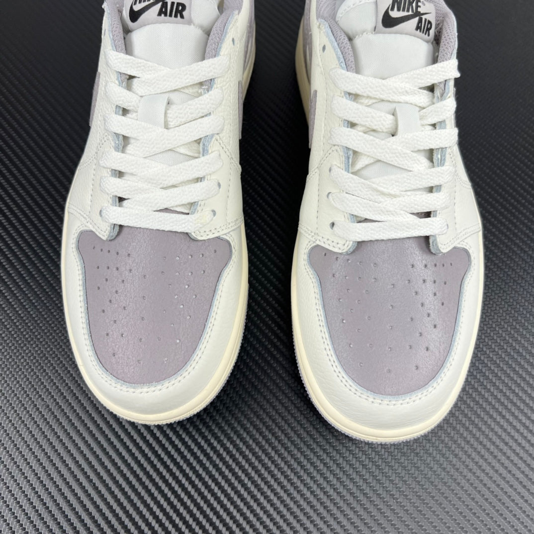 Front view of white low-top sneakers with perforated toe and lavender-gray overlays.