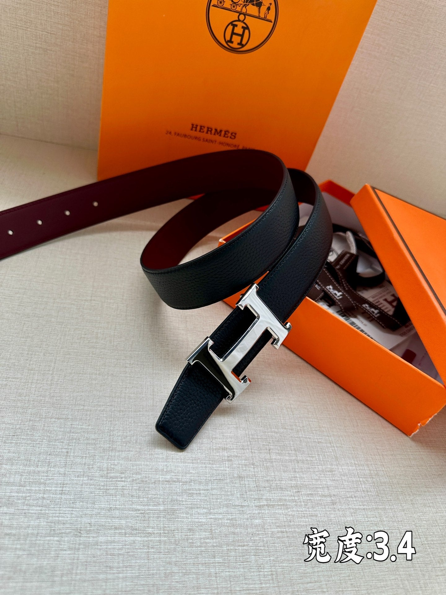 Leather belt with dark strap, burgundy underside, and silver buckle