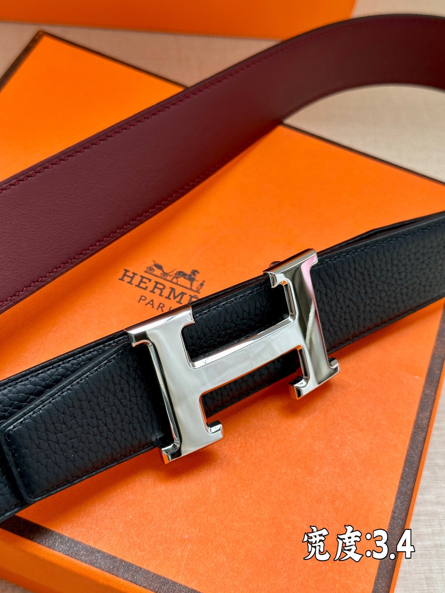 Leather belt close-up with dark strap and silver H buckle