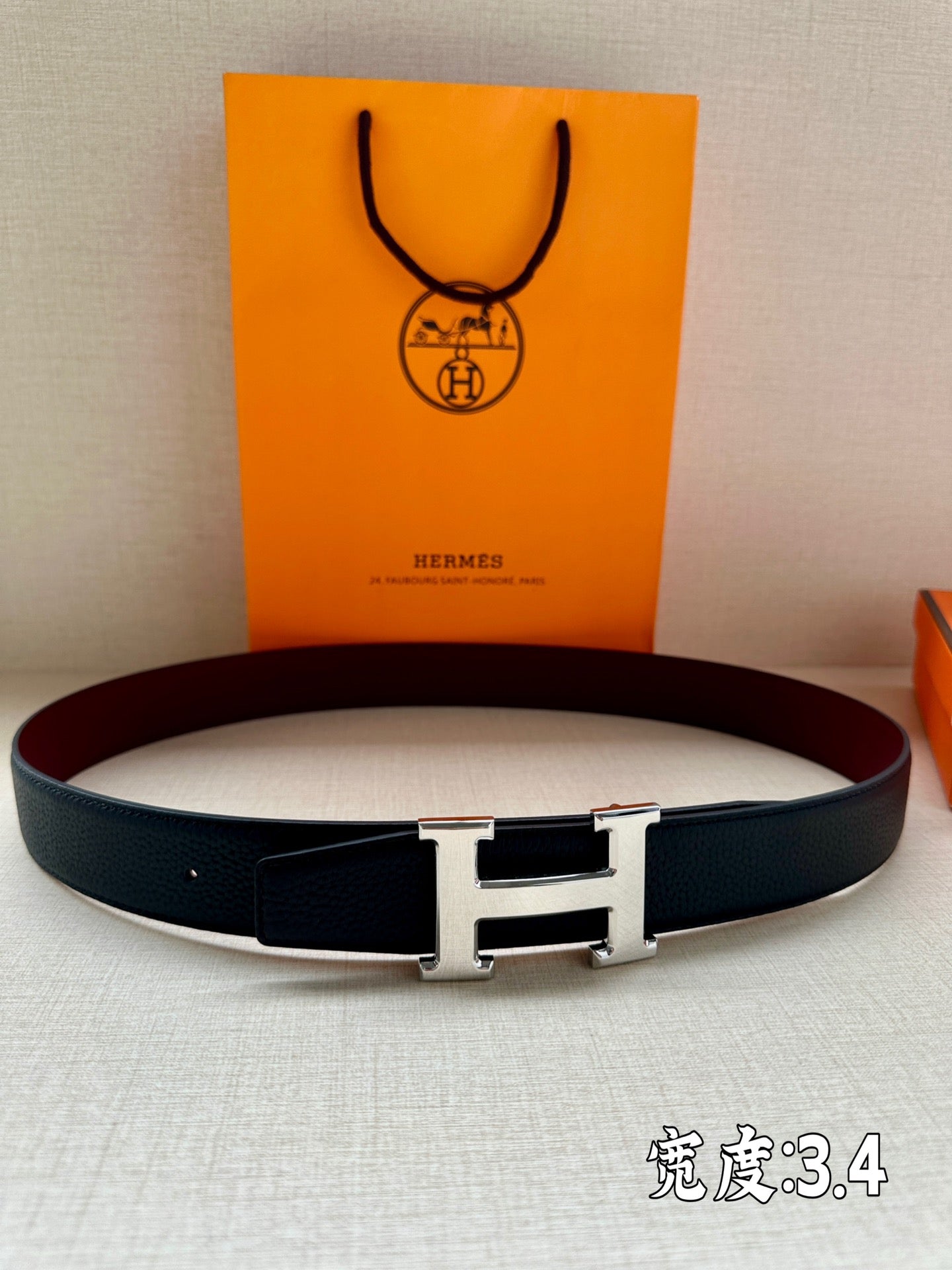 Leather belt with dark strap and silver H-style buckle