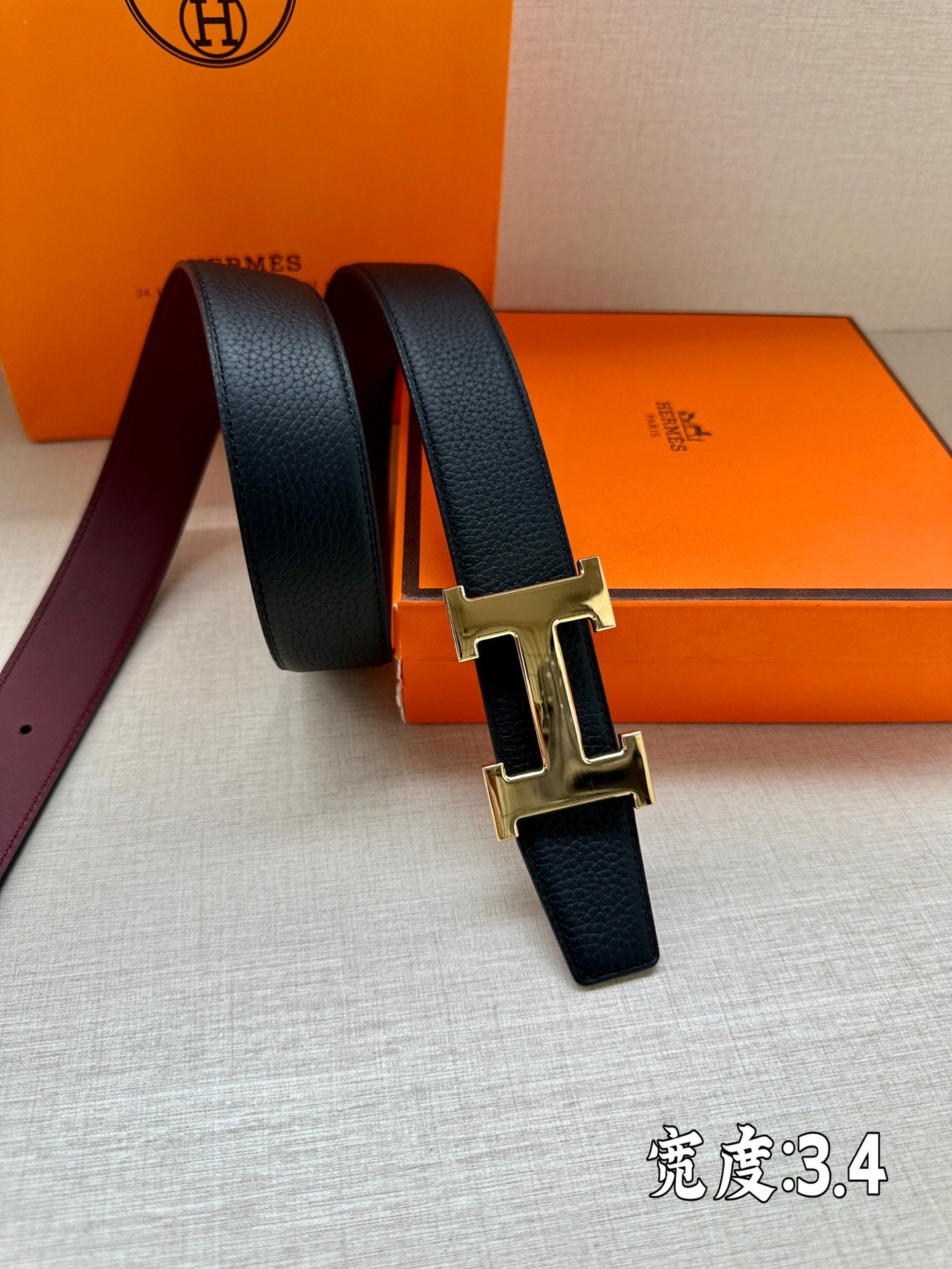Leather belt with dark strap and gold-tone H buckle, end loop visible