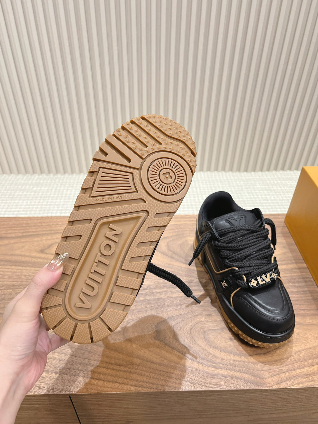 Trainer sneaker outsole with patterned tan tread and black upper, lace-up
