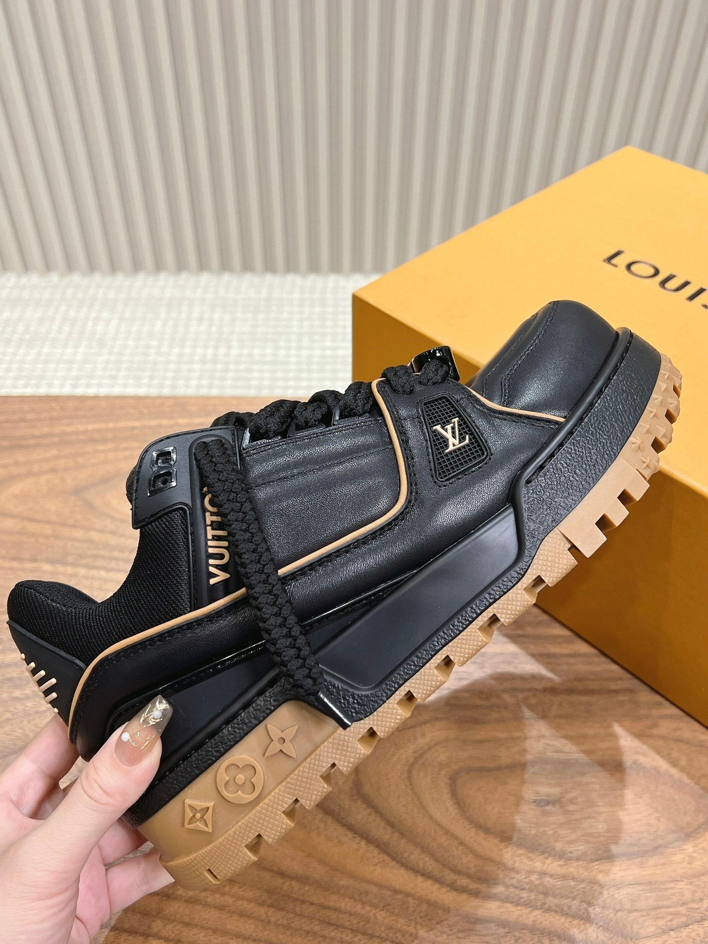 Louis Vuitton trainer sneaker in black with LV logo, gold trim, tan lug sole