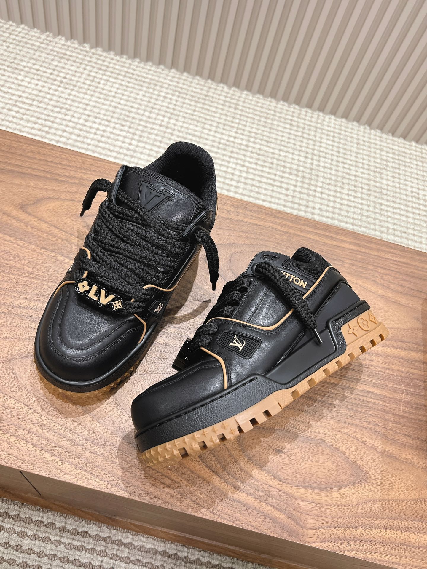 Black trainer sneaker with laces, tan lug sole and gold-trimmed LV side details