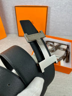 Black leather belt with silver-toned H buckle close-up