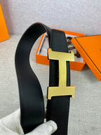 Black leather belt showing gold-toned H buckle detail