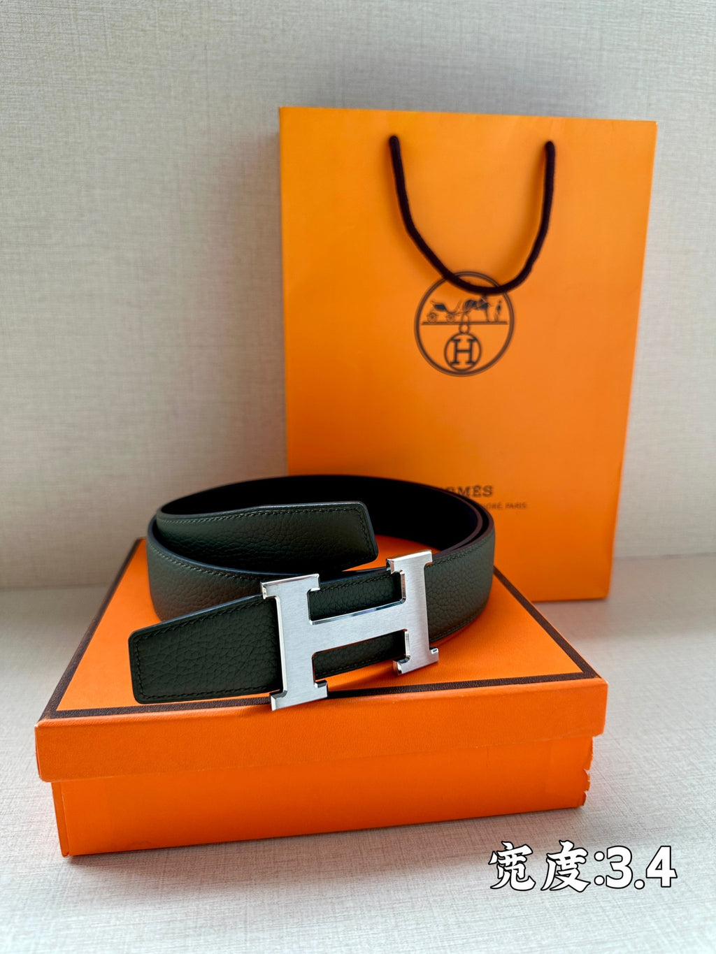 Green leather belt with metallic H buckle, flat front view