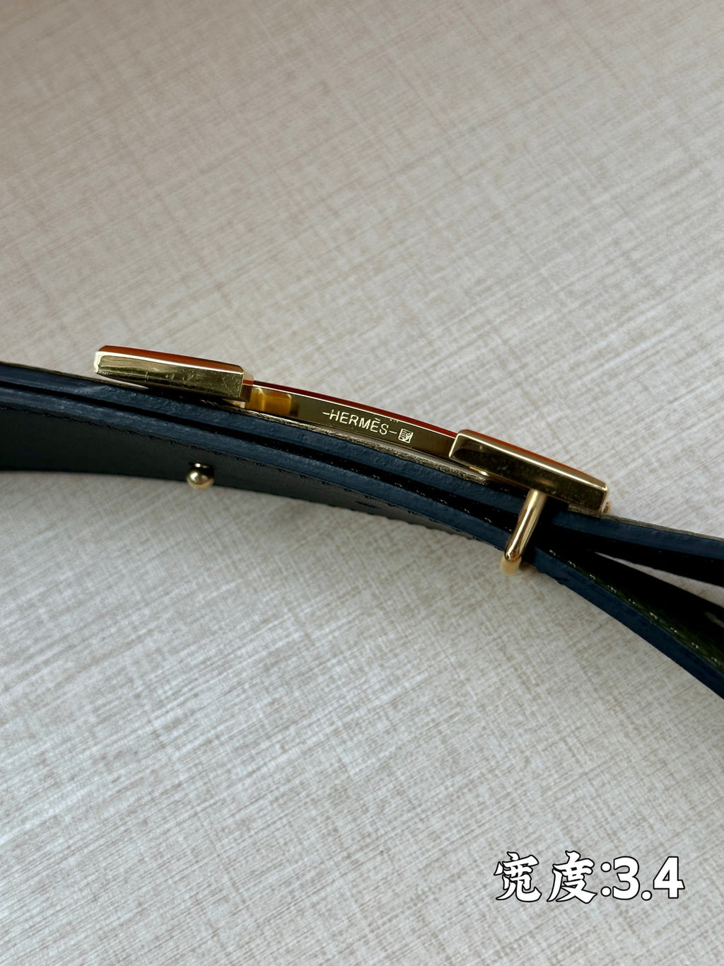 Green leather belt with gold-tone bar buckle, side view