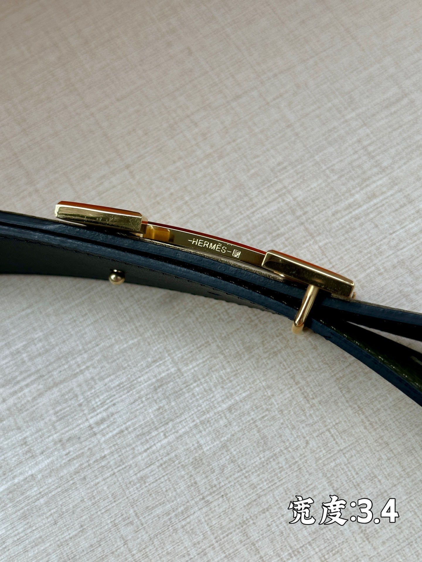 Green leather belt with gold-tone bar buckle, side view