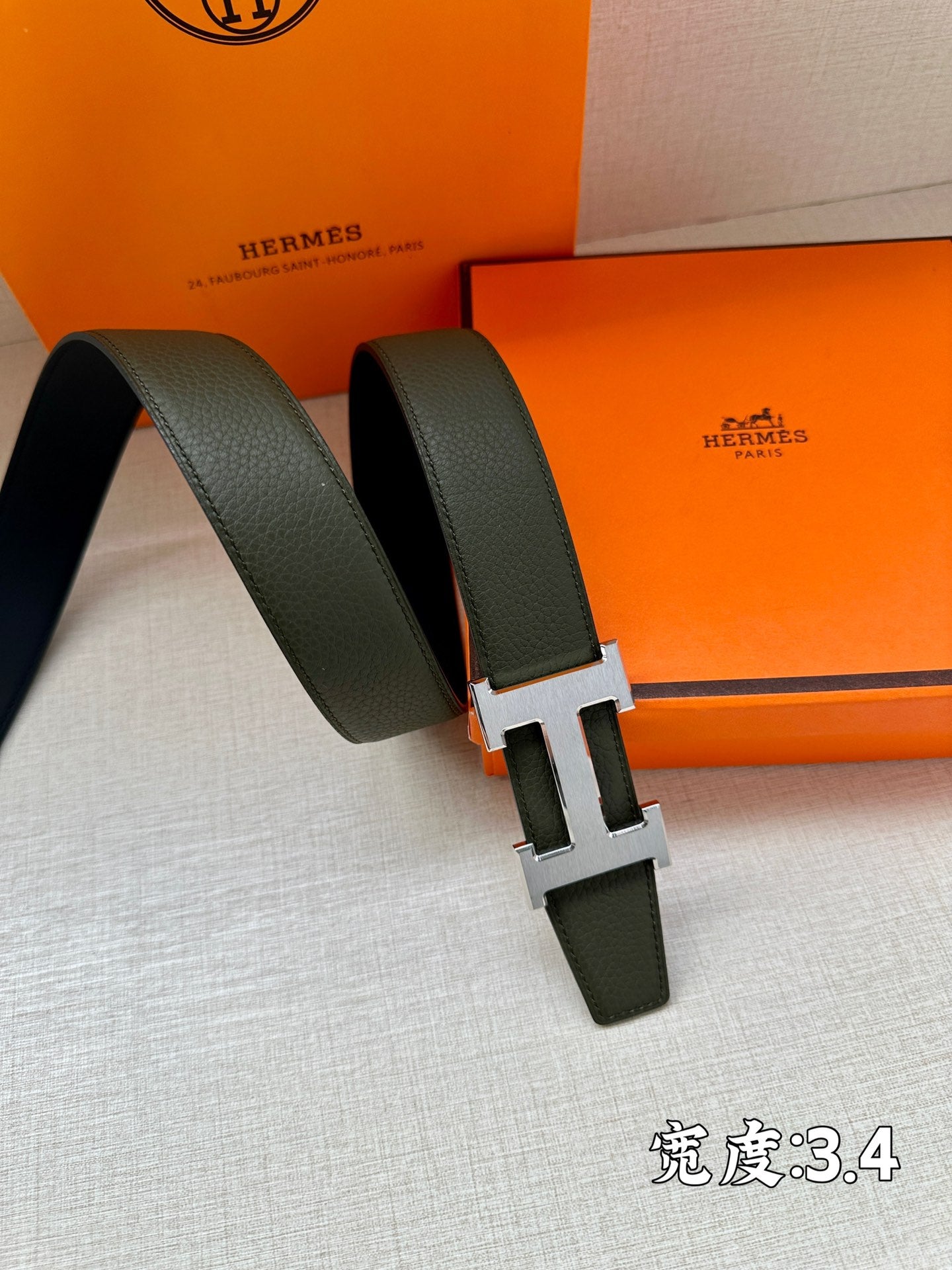 Green leather belt with metallic H buckle and loop keeper
