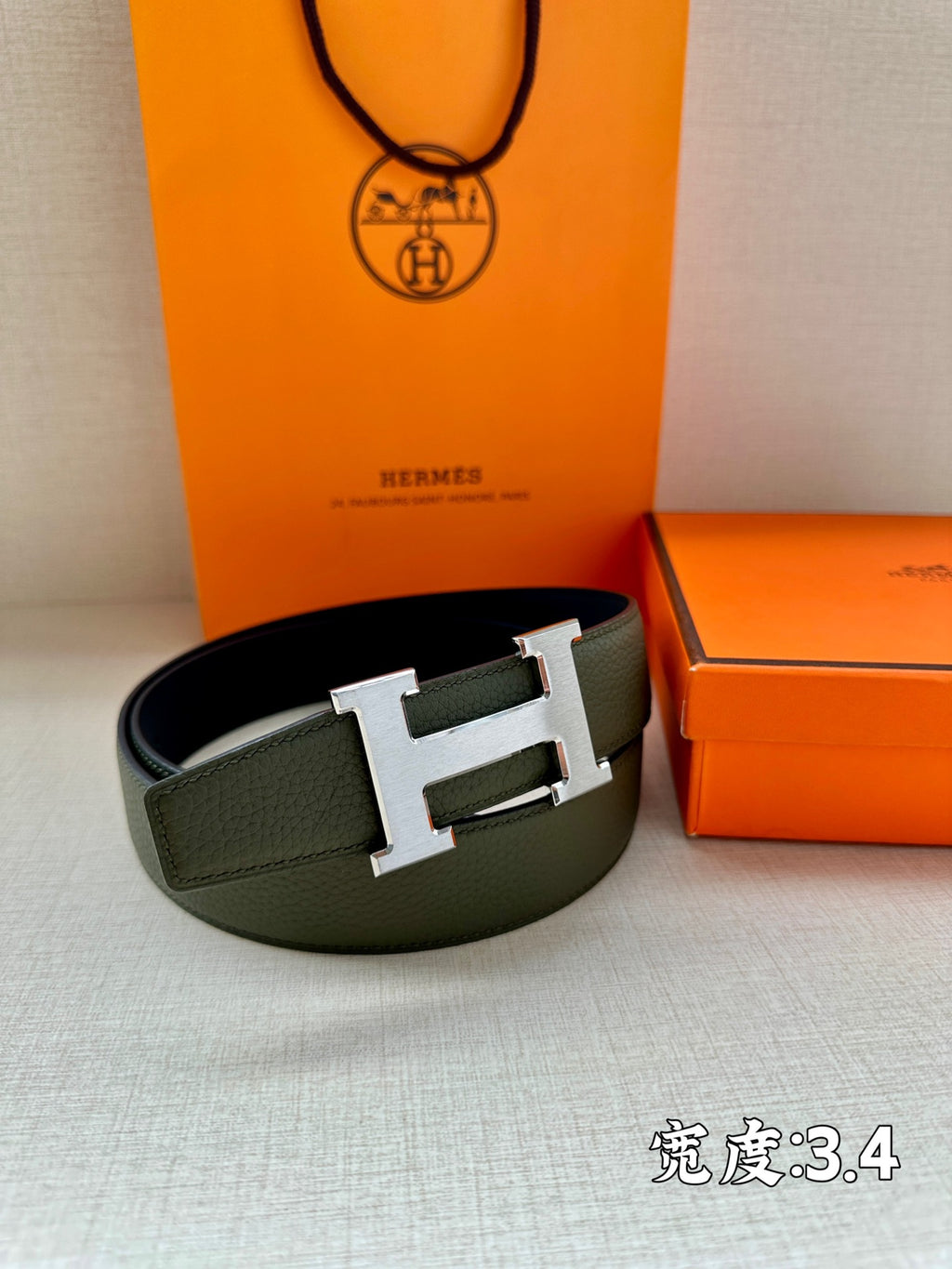 Green leather belt with gold-tone H buckle on textured leather
