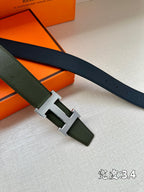 Green leather belt with silver-toned H buckle and punched holes