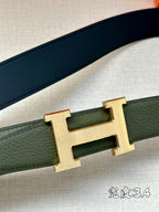 Green leather belt strap with gold-tone H buckle, close-up