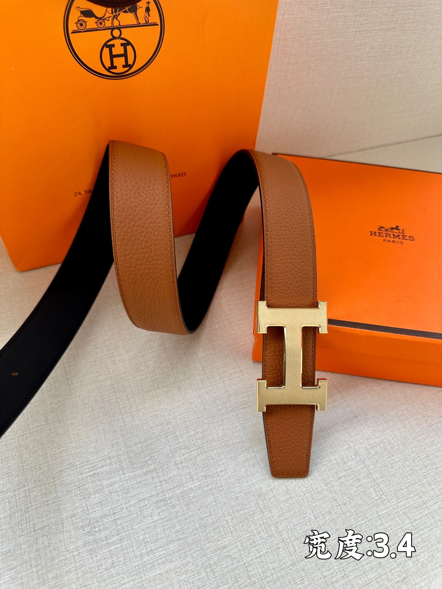 Brown leather belt with silver H buckle, long strap ends