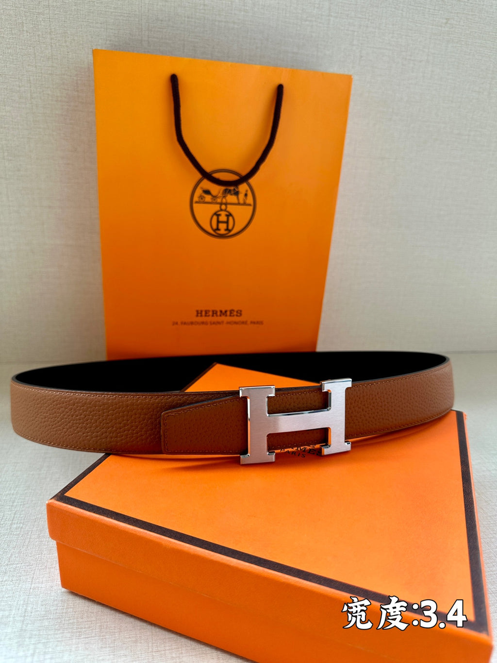 Brown leather belt with silver H buckle, presented on box