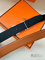 Navy leather belt with silver H buckle, close-up of holes