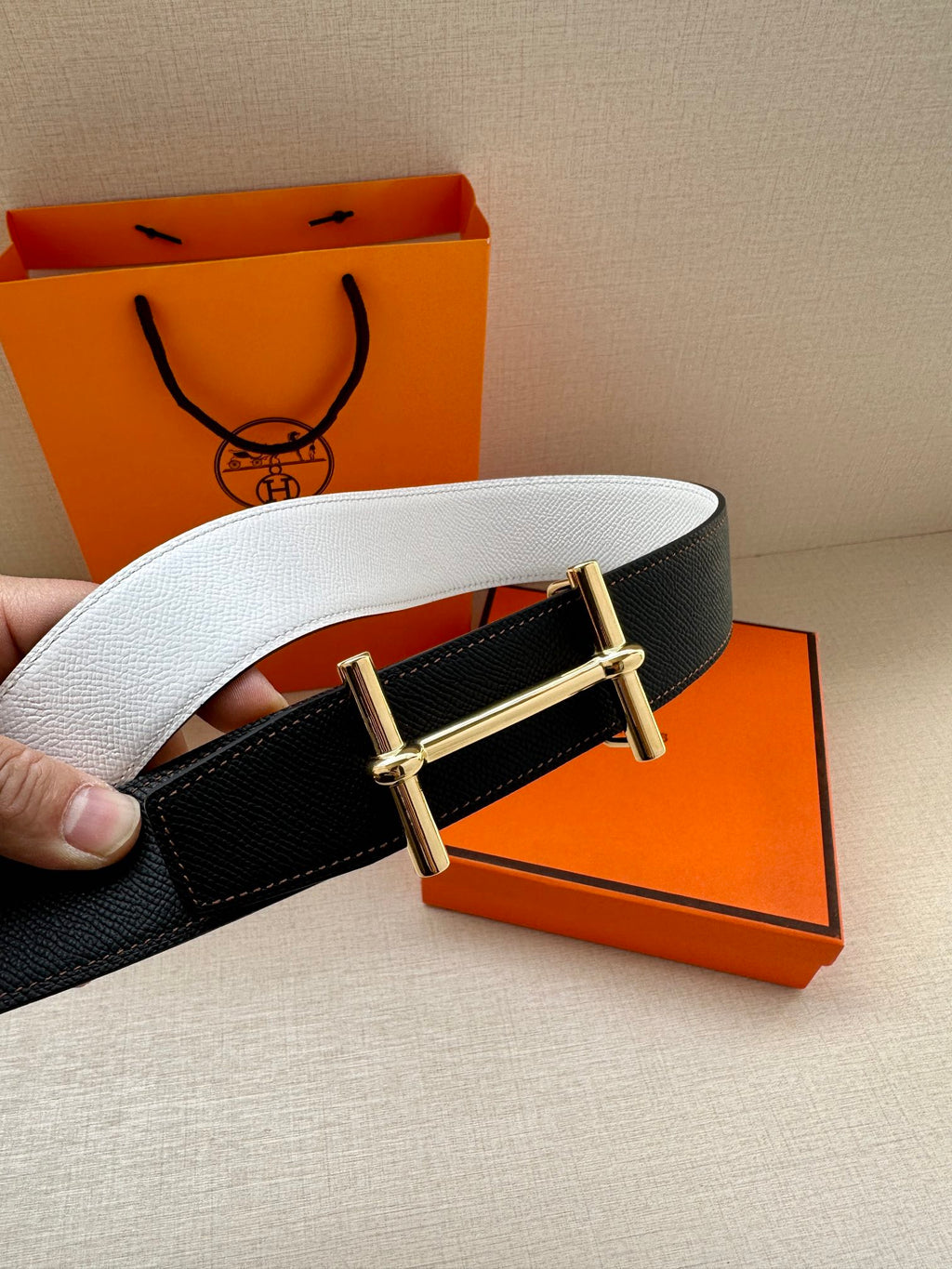 Dark leather belt with silver-tone buckle, side view with light inner strap.
