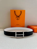 Two-tone belt flat lay: dark leather with light lining and silver-tone buckle.