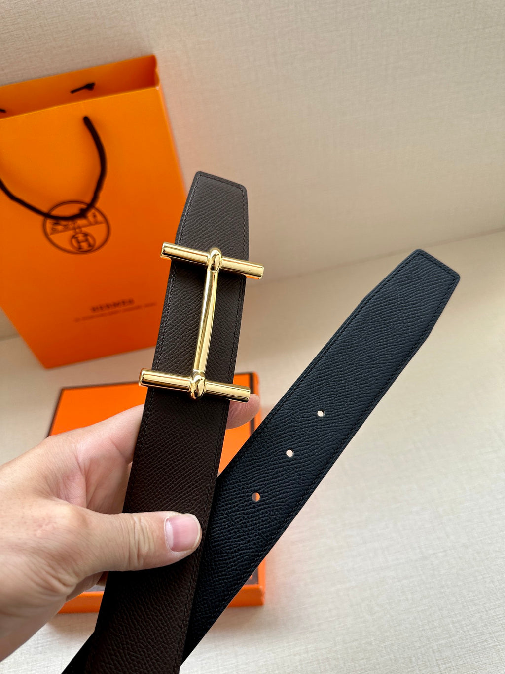 Hermes belt dark textured leather, gold-tone bar buckle detail.