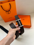 Hermes belt dark textured leather, silver buckle frame shown close-up.