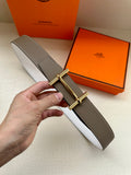 Taupe leather belt with gold double-prong buckle and textured strap detail