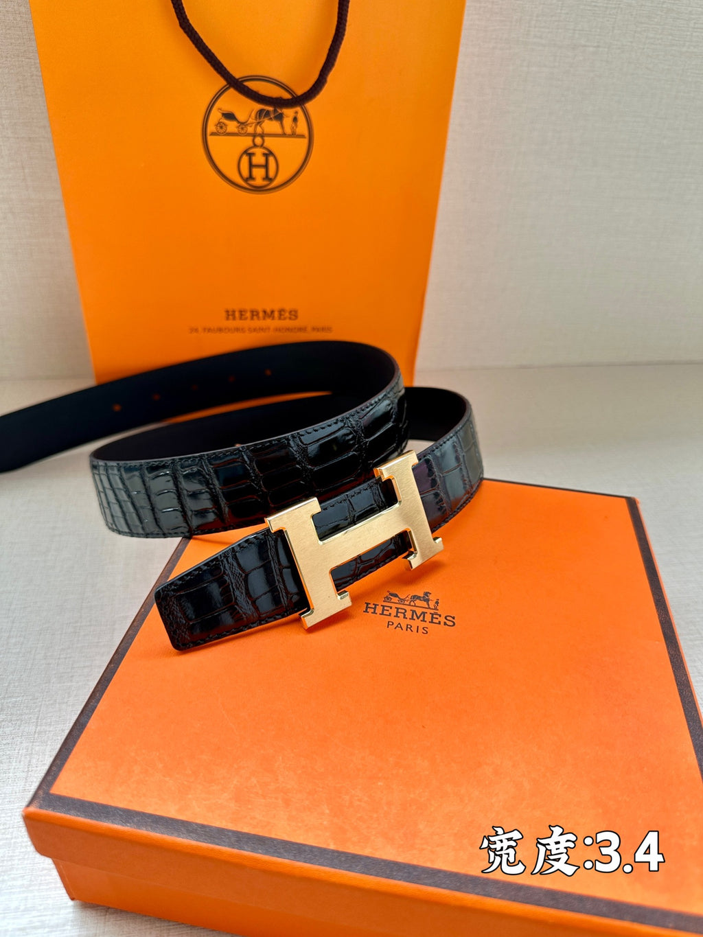 Hermes belt with dark embossed leather and large silver H buckle.