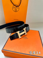 Hermes belt with dark embossed leather and large silver H buckle.