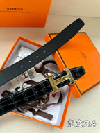 Hermes belt top view with dark leather strap, gold-tone H buckle, and hole row