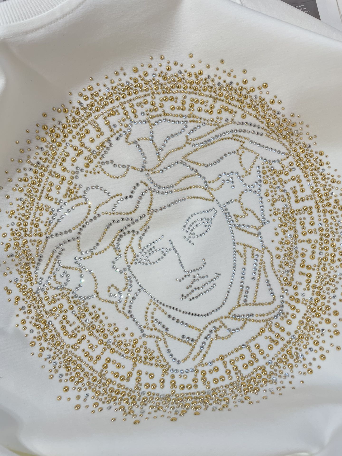 Versace white sweatshirt with close-up gold Medusa face beadwork print
