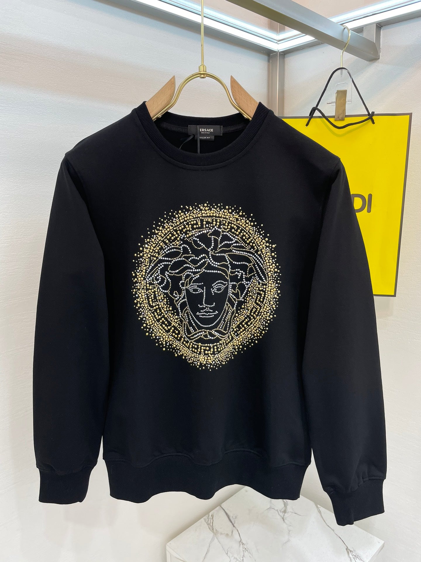 Versace black sweatshirt with gold Medusa face graphic, crew neck and long sleeves