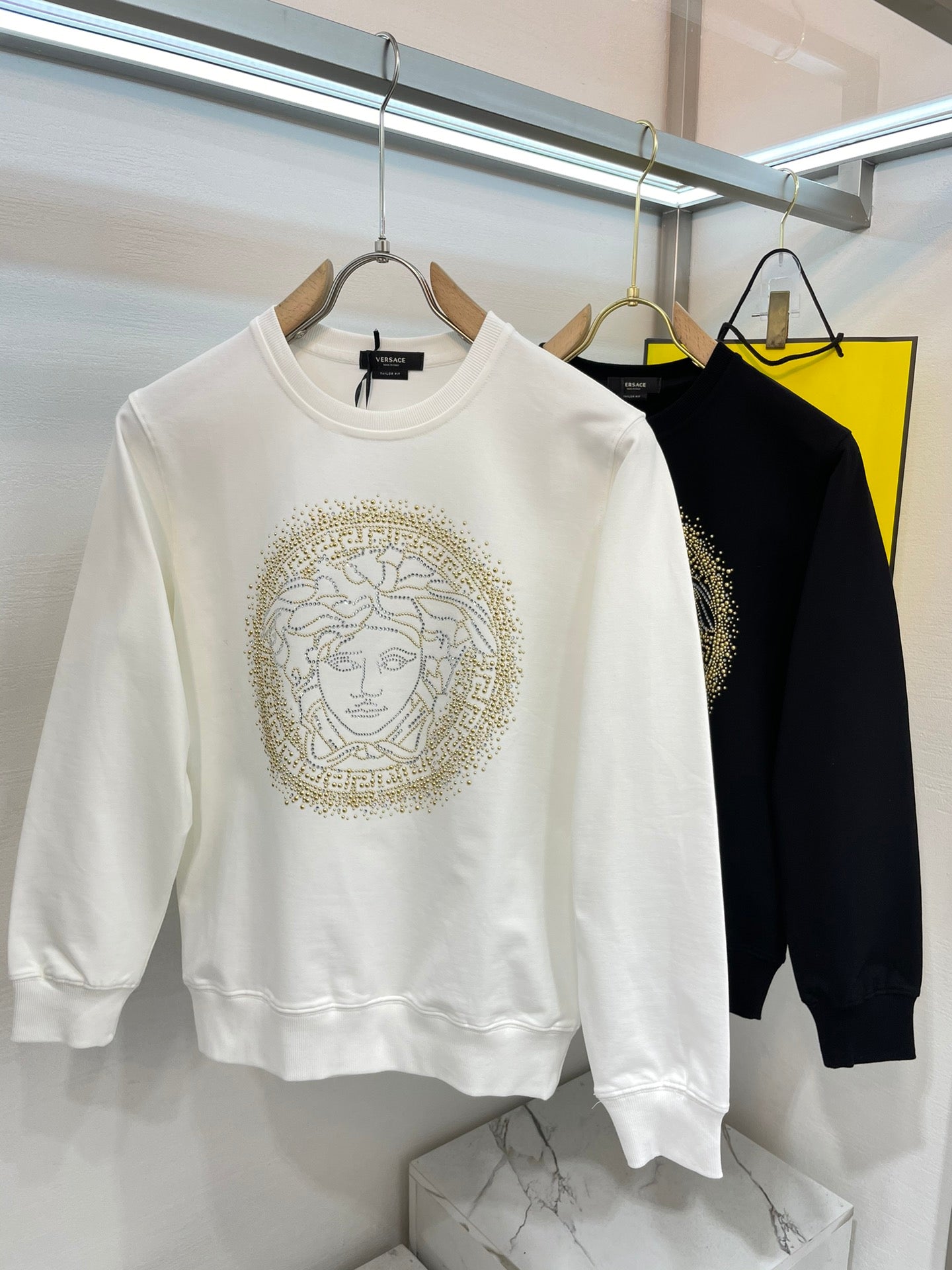 Versace white sweatshirt with gold Medusa face graphic, crew neck and long sleeves