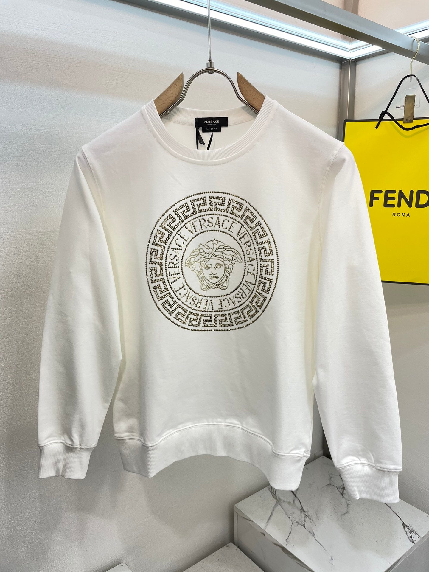White crewneck sweatshirt with front gold medallion logo print