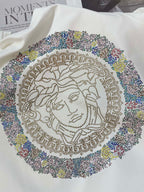 White sweatshirt close-up of multicolor rhinestone Medusa medallion