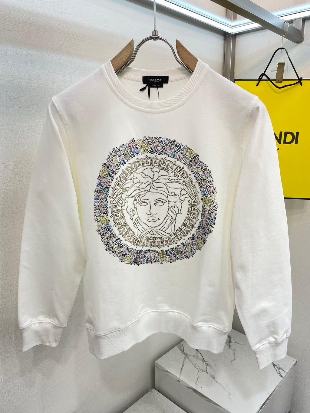 White crewneck sweatshirt with rhinestone Medusa medallion graphic