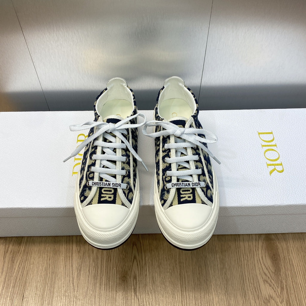 Navy blue logo-print low-top sneakers with white laces and white rubber sole.