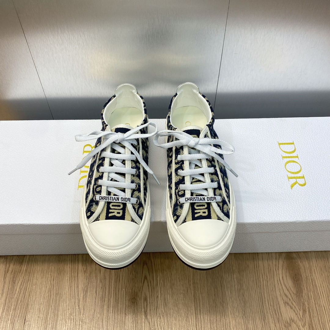 Navy blue logo-print low-top sneakers with white laces and white rubber sole.
