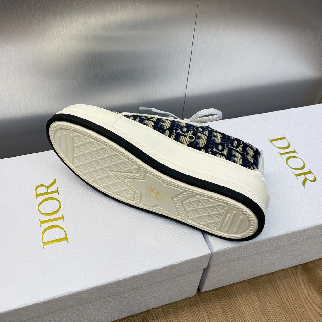 Sneaker outsole view with navy logo-print upper and white textured tread sole.