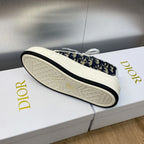 Sneaker outsole view with navy logo-print upper and white textured tread sole.