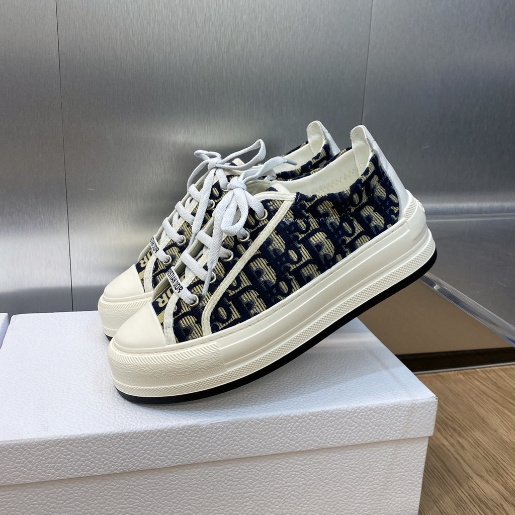 Navy blue logo-print low-top sneakers with white laces and thick white sole.