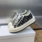 Navy blue logo-print low-top sneakers with white laces and thick white sole.